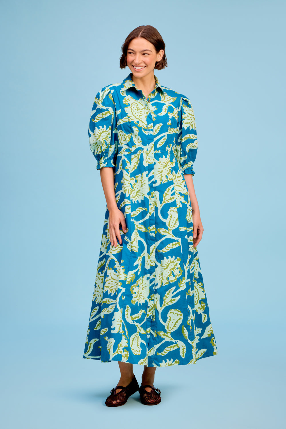 LIVRO Rosie Dress in blue and yellow botanical print featuring a collared neckline, puff sleeves and flowing maxi silhouette at Harringtons Boutique.