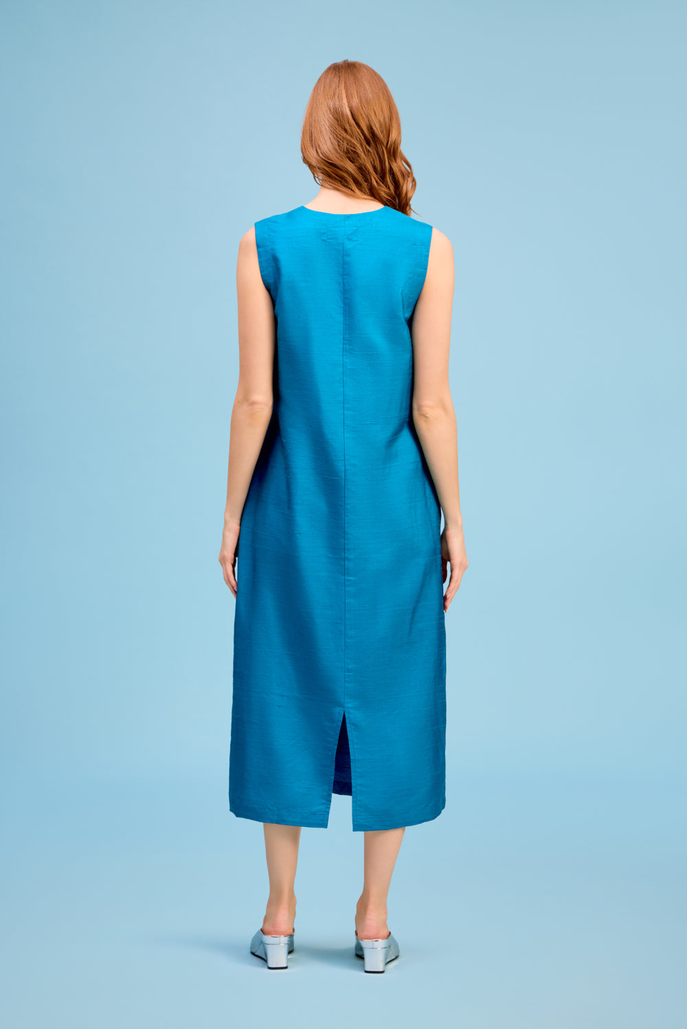 Back view of LIVRO Column Dress in turquoise blue featuring a sleeveless design and flowing midi-length silhouette.