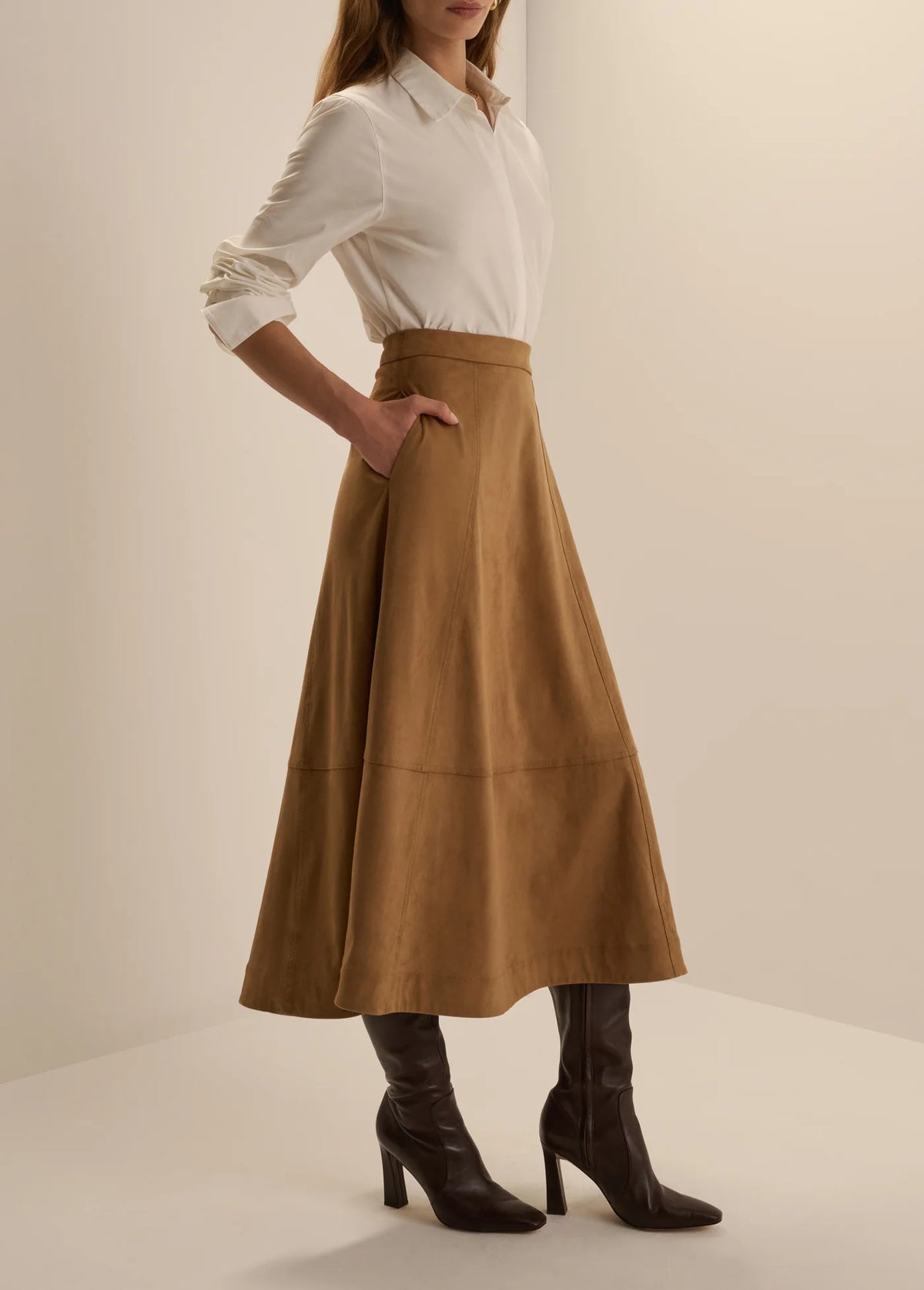Side view of Favorite Daughter Aspen camel brown midi skirt with tall boots
